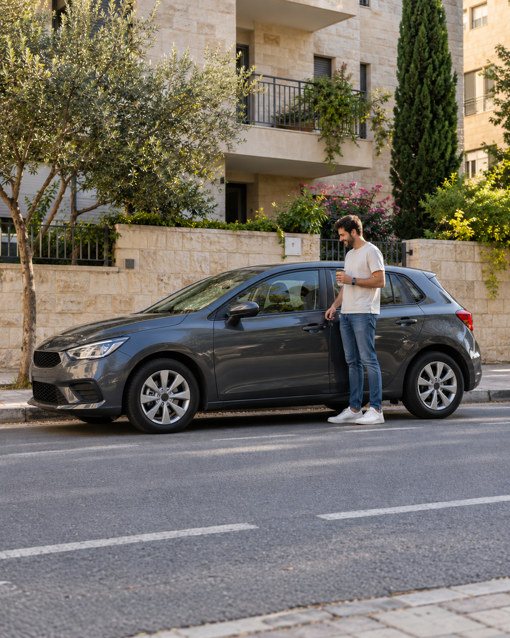 בעל רכב מחייך ליד הרכב שלו
